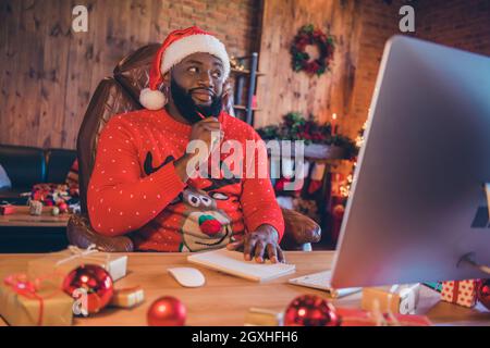Portrait of attractive minded guy using computer writing notes creating dream wish staying at home loft industrial style interior indoors Stock Photo