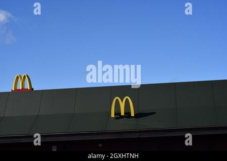 The Trademarked McDonalds logos on a roof of a drive thru on a summers day Stock Photo