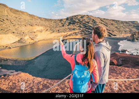 Hikers taking phone photo hiking in Spain mountain landscape . Travel couple tourists on summer hike with backpack. Woman, caucasian man hikers happy Stock Photo