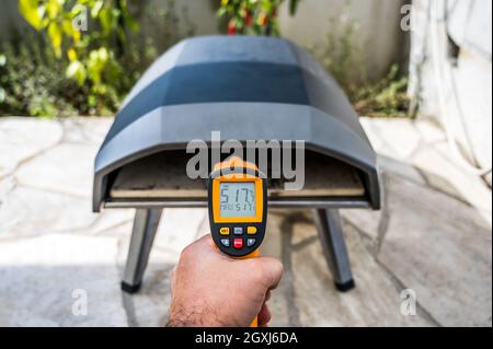 https://l450v.alamy.com/450v/2gxj6da/making-homemade-pizza-in-portable-high-temperature-pizza-ovenchecking-the-stone-temperature-with-special-ir-thermometer-special-gas-fueledpizza-ov-2gxj6da.jpg