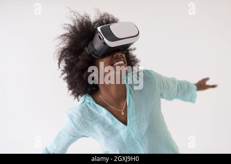 Happy african american girl getting experience using VR headset glasses of virtual reality, isolated on white background Stock Photo