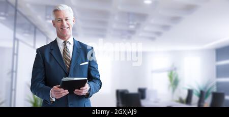 Portrait of senior businessman using tablet in front of his modern office Stock Photo