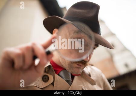 Vintage detective using a magnifying glass Stock Photo