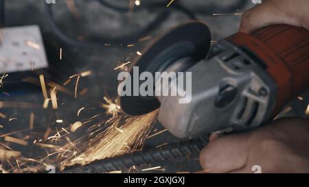 Worker man using electric wheel grinding and cutting on steel structure have spark from the grinding wheel at production industrial Stock Photo