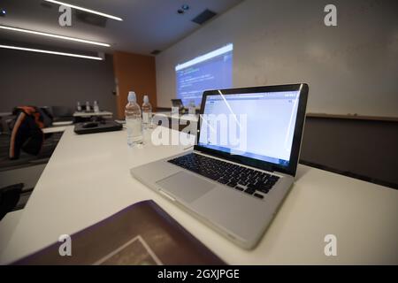 empty it classroom with program code on projector screen and modern laptop computers on table Stock Photo