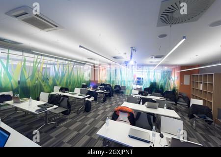 empty it classroom with program code on projector screen and modern laptop computers on table Stock Photo