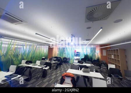 empty it classroom with program code on projector screen and modern laptop computers on table Stock Photo
