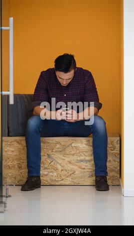 young man in crative box working on smart phone, startup business modern office room  interior Stock Photo