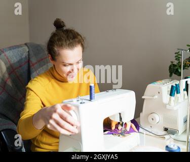 Female seamstress using sewing machine while working at home Stock Photo