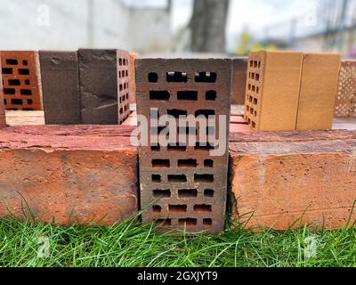 Different types of bricks stacked beautifully on green grass Stock Photo