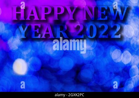 New Year, 2022. Translucent numbers of the year on a blue-toned background of bright lights out of focus. Horizontal design. Happy New Year 2022. Stock Photo