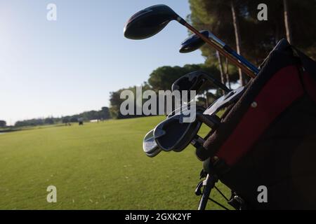 close up of golf bag on course with  club and ball in front at beautiful sunrise Stock Photo