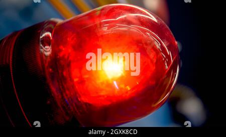 Closeup image of glowing red fire alarm light installed in modern building. Stock Photo