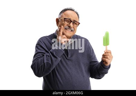 Mature man with a lollipop ice cream holding his cheek and having a toothache isolated on white background Stock Photo