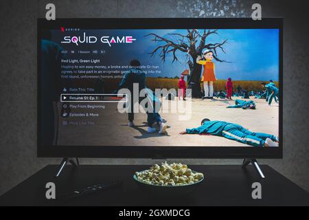 Watching Squid game show on TV. Squid game is a South Korean survival drama television series streaming on Netflix Stock Photo
