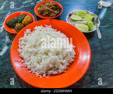 Meal in Bangladesh - Rice, Alo vorta, Shim borta and chicken curry Stock Photo