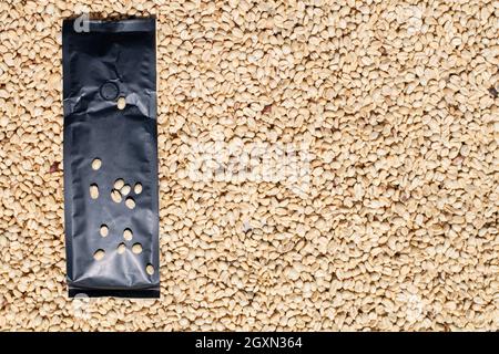 Modern instant coffee bag packaging in black color. Isolated on bottom coffee beans. Stock Photo
