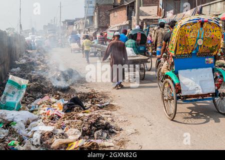 DHAKA, BANGLADESH - NOVEMBER 22, 2016: Piles of garbage and rickshaws at Sadarghat-Gabtoli Road in central Dhaka, Bangladesh Stock Photo