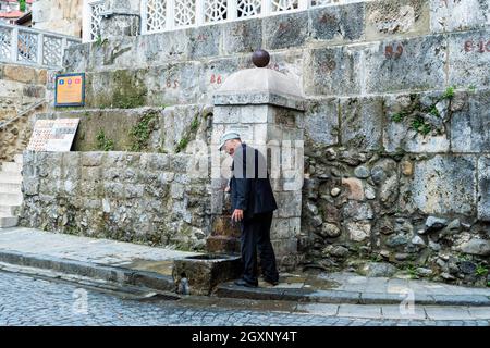 Man washing his hands at the well, Prizren, Kosovo Stock Photo