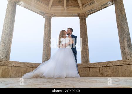 Wedding couple just married kissing inside a temple Stock Photo