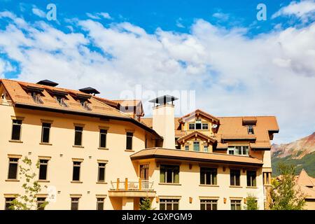 Beautiful tan and red roofed structures against white and blue sky Stock Photo