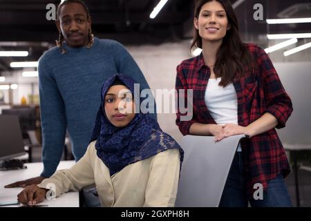 young multiethnics business team of software developers working together using laptop computer while writing programming code at modern startup office Stock Photo