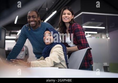 young multiethnics business team of software developers working together using laptop computer while writing programming code at modern startup office Stock Photo