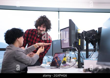 young software developers couple using laptop and desktop computer while writing programming code at modern creative startup office Stock Photo