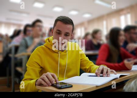 a portrait of a concentrated Student using a calculator while calculating in a math class Stock Photo