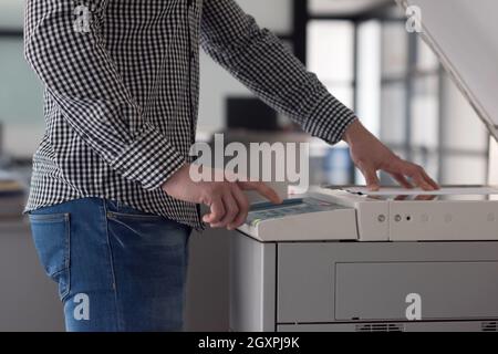 young business man copy documents on copy machine at modern startup office interior, casual clothes Stock Photo