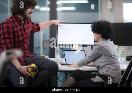 young software developers couple using laptop and desktop computer while writing programming code at modern creative startup office Stock Photo