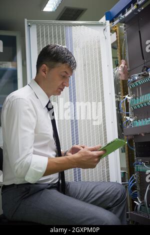 network engineer working in  server room, corporate business man working on tablet computer Stock Photo