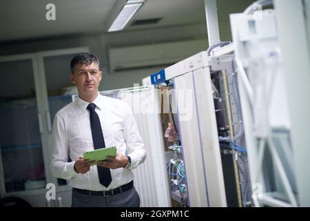 network engineer working in  server room, corporate business man working on tablet computer Stock Photo