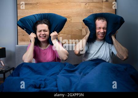 Loud Neighbor Making Noisy Party While Couple Sleeping In Bed Stock Photo