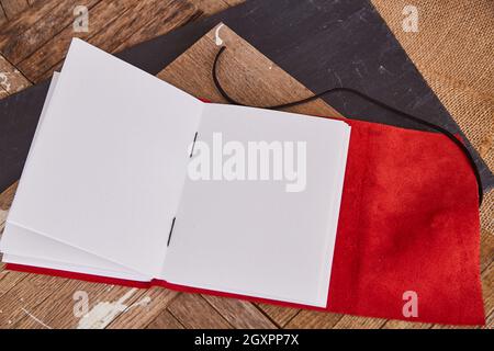 Blank pages of open book with red leather on old wood Stock Photo