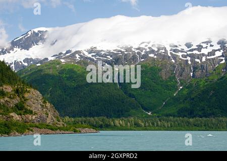 Snowcapped mountain between low clouds, Cordova, Alaska, USA Stock Photo