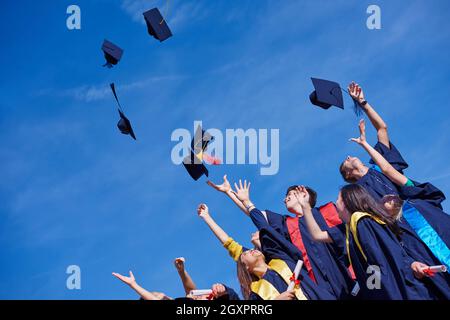 high school students graduates tossing up hats over blue sky Stock ...