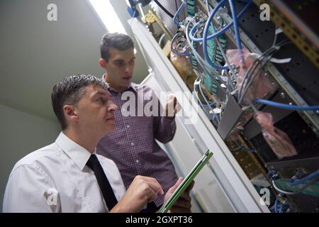 business people group working on tablet computer, network engineers in server room Stock Photo
