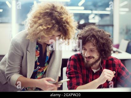 young software developers couple using laptop and desktop computer while writing programming code at modern creative startup office Stock Photo