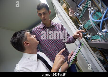 business people group working on tablet computer, network engineers in server room Stock Photo