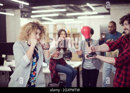 multiethnics startup business team of software developers having fun while boxing at office,excited diverse employees laughing enjoying funny activity Stock Photo