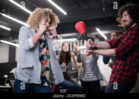 multiethnics startup business team of software developers having fun while boxing at office,excited diverse employees laughing enjoying funny activity Stock Photo