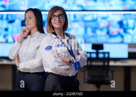 group portrait of female security operator while working in a data system control room offices Technical Operator Working at  workstation with multipl Stock Photo