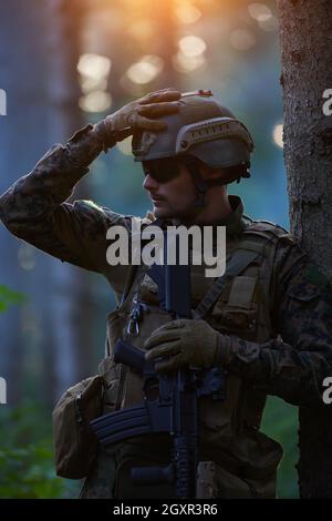 soldier portrait with  protective army tactical gear  and weapon having a break and relaxing Stock Photo