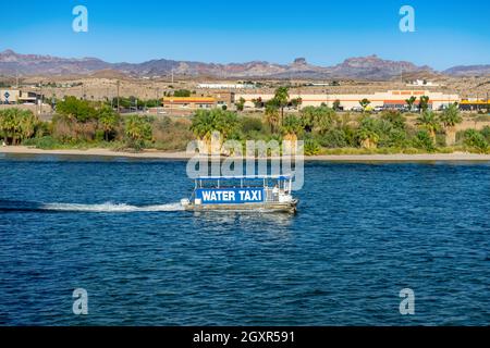 Laughlin, NV, USA – August 27, 2021: A water taxi on the Colorado River travels between casinos in Laughlin, Nevada, with a background view of Bullhea Stock Photo