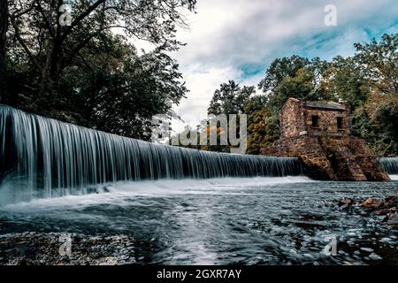 Tranquil speedwell lake park waterfalls in Morristown, NJ with misty motion blur from slow shutter speed Stock Photo