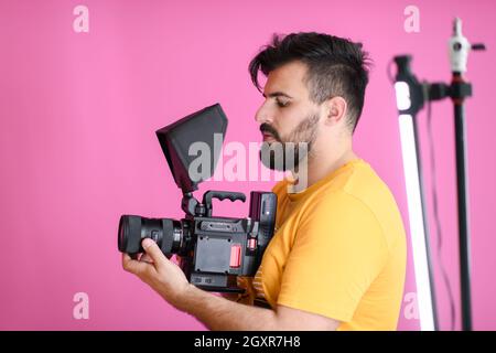 a cameraman with professional equipment shoots video clips in the studio Stock Photo
