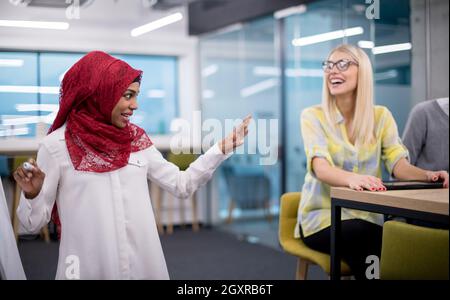 young black muslim businesswoman giving presentations to her multiethnic business team at modern startup office Stock Photo