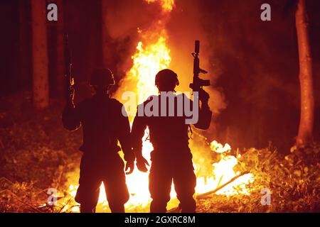 special marines military forces squad soldiers group portrait after finished mission complete fire in background Stock Photo