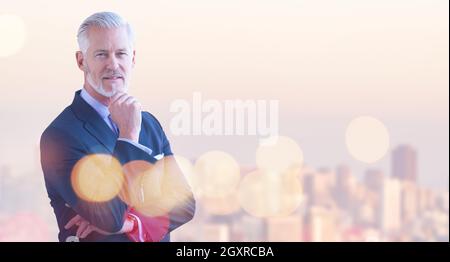 Portrait of senior businessman in front of big modern city Stock Photo